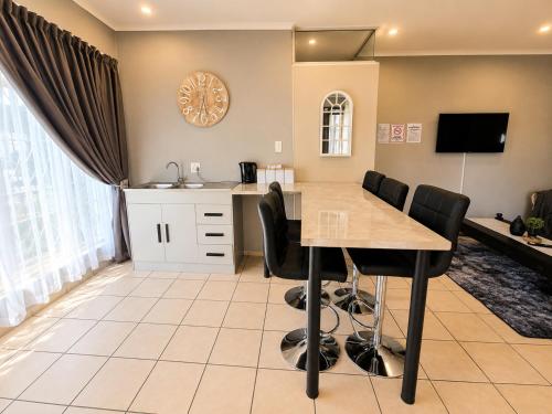 a kitchen and dining room with a table and chairs at Zhantique Guest House 2- Unit 6 in Boksburg
