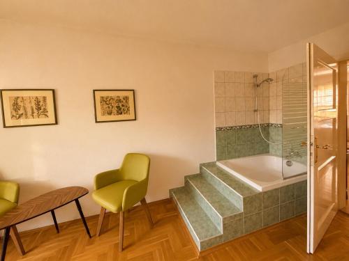 a bathroom with a shower and a staircase with a tub at Landhaus Sunnberg in Gersdorf
