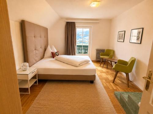 a bedroom with a bed and a desk and a window at Landhaus Sunnberg in Gersdorf