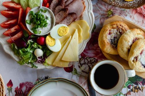 a table with a plate of food and a cup of coffee at Agroturystyka Akacjowe Zacisze- pokoje ze śniadaniami, sauna, balia, tarasy wśród drzew, slow life in Stańkowa