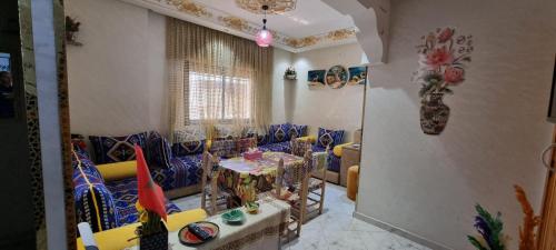 a living room with blue and yellow chairs and a table at Apprt Ennakhil 1 in El Jadida