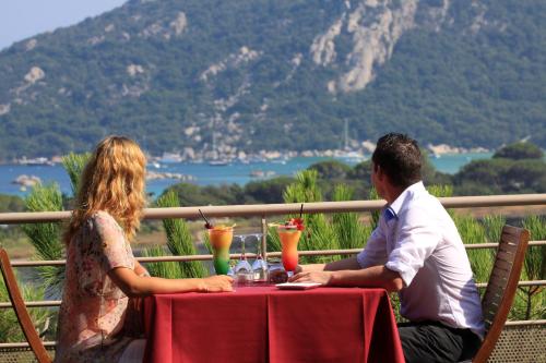 a woman and a man sitting at a table at Hôtel Castell'Verde in Porto-Vecchio