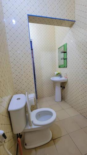 a bathroom with a toilet and a sink at WamkHouse in Jambiani