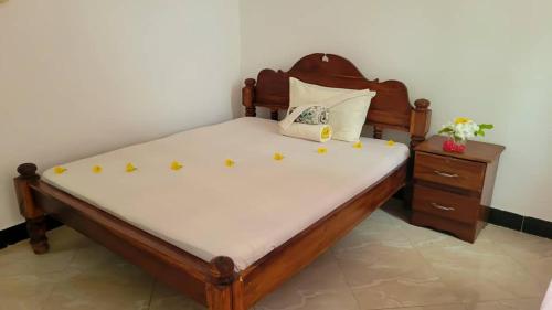 a bedroom with a wooden bed with yellow stars on it at WamkHouse in Jambiani