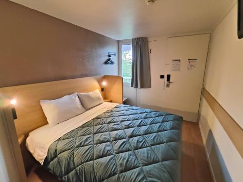 a bedroom with a bed and a window at Première Classe Tarbes - Bastillac in Tarbes