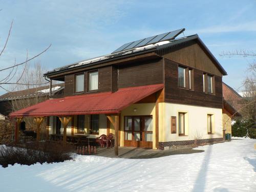 a house with solar panels on the roof in the snow at Chata Pod Hájkem in Vrchlabí