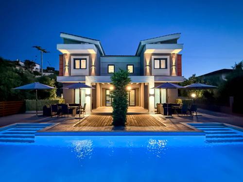 a villa with a swimming pool at night at Assos Luxury Villas in Pefkochori