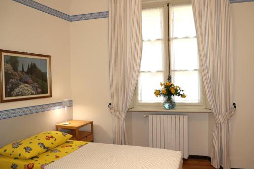 a bedroom with a bed and a window with curtains at Teddy Bear trilocale, family, centro Biella in Biella