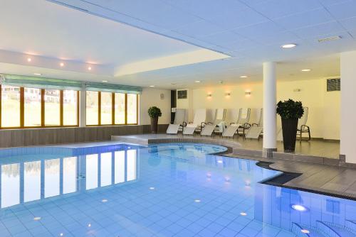 una grande piscina in un edificio con sedie di Apart-Hotel Filomena a Lech am Arlberg