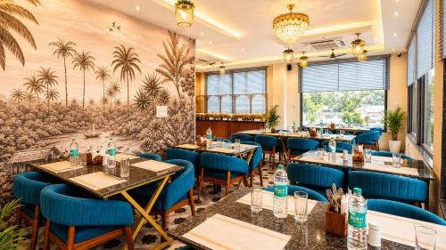 a restaurant with blue tables and blue chairs at Hotel The Montara Near Ganga Ghat in Rishīkesh