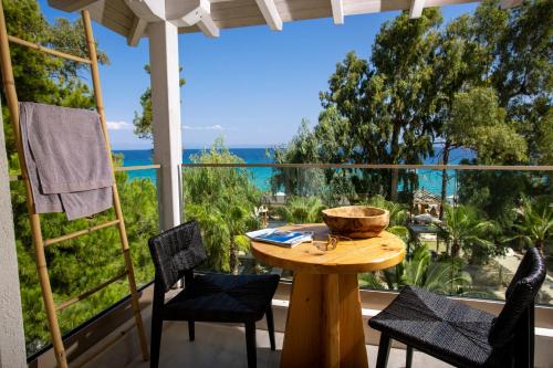 a table on a porch with a view of the ocean at MAKO Sea & Suites in Pefkochori