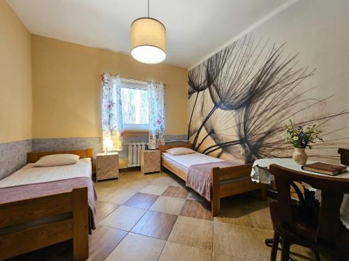 ein Zimmer mit zwei Betten und einem Gemälde an der Wand in der Unterkunft Pensjonat Libra in Karolinów