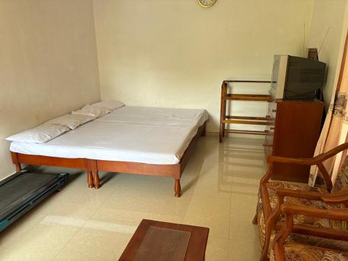 a small bedroom with a bed and a chair at Cloud Nine in Diyatalawa