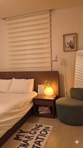 a bedroom with a bed and a chair and a table at 4 Beds Busan Gwangalli Big Star Stay in Busan