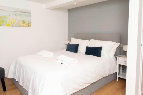 a bedroom with a bed with white sheets and blue pillows at Self-contained flat in Girton