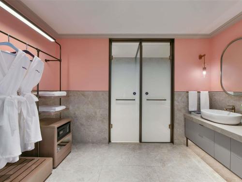 a bathroom with pink walls and a sink at Mercure Guangzhou Nansha in Guangzhou