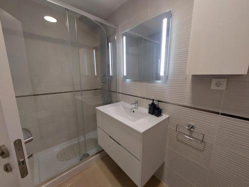 a white bathroom with a sink and a shower at Playa Torre de la Sal - Primera Linea in La Estación
