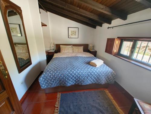 a bedroom with a bed with a blue comforter at Casa da Torre in Sao Pedro de Tomar