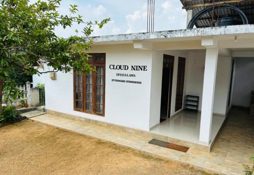 a white building with a sign on the side of it at Cloud Nine in Diyatalawa