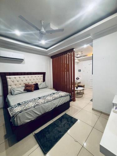 a bedroom with a bed with a ceiling fan at Saffron Nest in Zirakpur