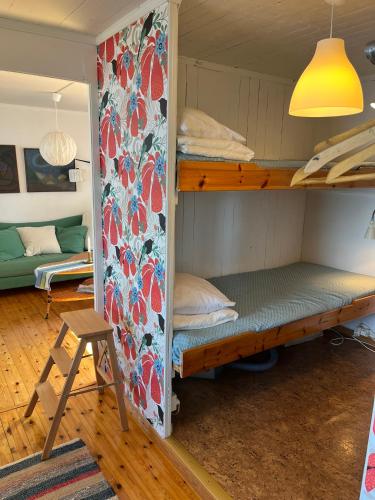 a room with two bunk beds and a chair at Svens Stuga in Burträsk