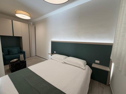 a bedroom with a bed and a blue chair at Casa Cloe in LʼAquila
