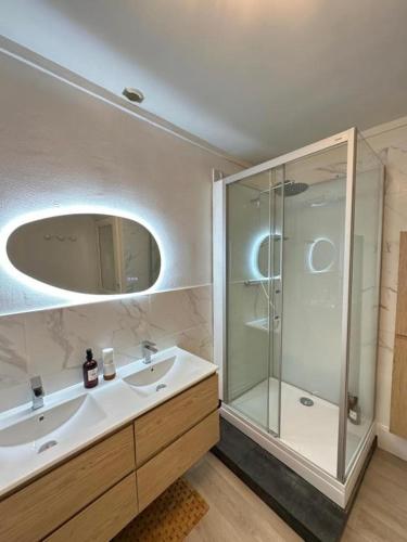a bathroom with a sink and a glass shower at La Villa Convivium - Chambres privées in Rouen
