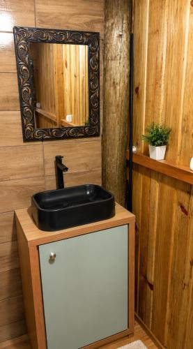 a bathroom with a black sink and a mirror at Chalés Recanto da Serra in Bocaina do Sul