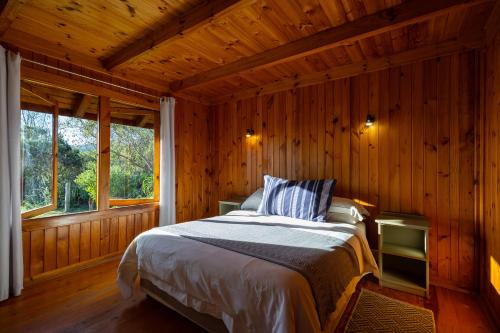 a bedroom with a bed in a wooden room at Reflections Eco-Reserve in Wilderness