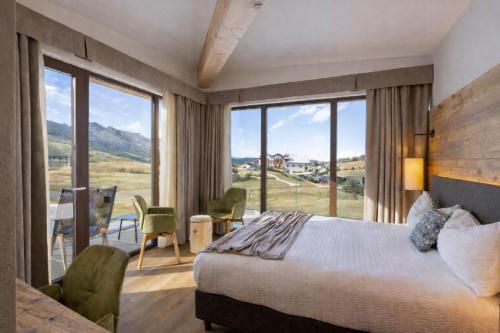 a bedroom with a bed and a large window at Albergo Vezzana in Passo Rolle