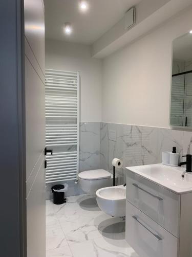a white bathroom with a toilet and a sink at Spazio Perlasca Apt 4 - Cernobbio Como Lake in Cernobbio