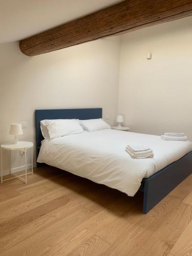 a bedroom with a large white bed with a blue headboard at Spazio Perlasca Apt 4 - Cernobbio Como Lake in Cernobbio
