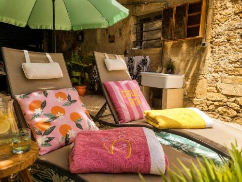 two chairs with towels and an umbrella on them at Chez Cathy in Villandraut