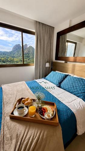 a tray of breakfast foods on a bed at Flat das Montanhas in Rio de Janeiro