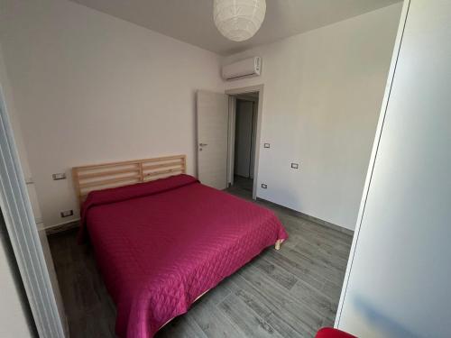 a small bedroom with a bed with a red blanket at Casa Fellini - Giardino e parcheggio gratuito in Venturina Terme