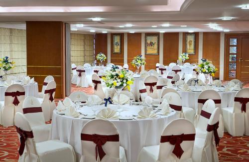a banquet hall with white tables and white chairs at City Seasons Hotel Dubai in Dubai