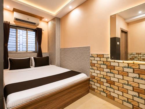 a bedroom with a bed and a mirror at Saba Guest House in Kolkata