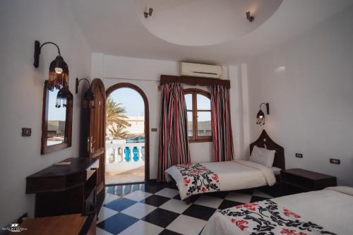 a bedroom with two beds and a view of the ocean at El Salam hotel in Dahab