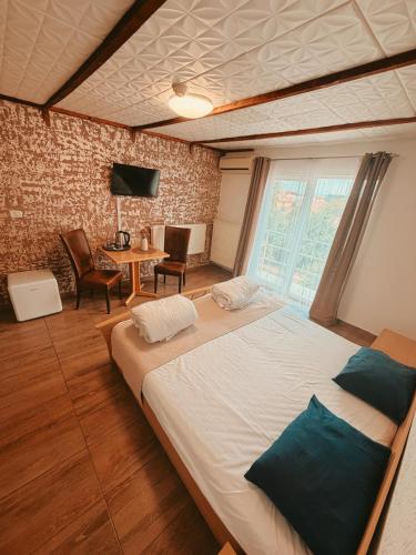 a bedroom with a large bed and a table at Pensiunea Johanna in Arad