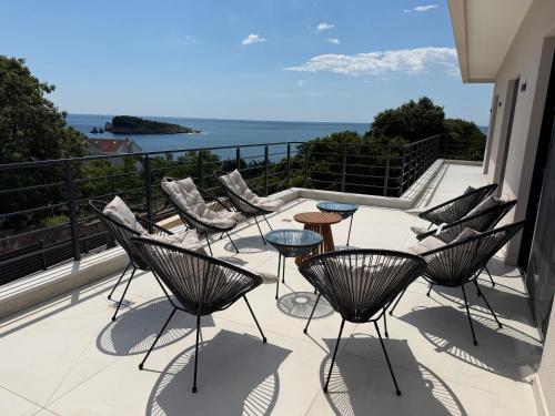 a balcony with chairs and tables and the ocean at Villa LiRa Star Bar Montenegro - Exclusive Adriatic Villa with Private Pool Starry Sky Lounge in Stari Ulcinj