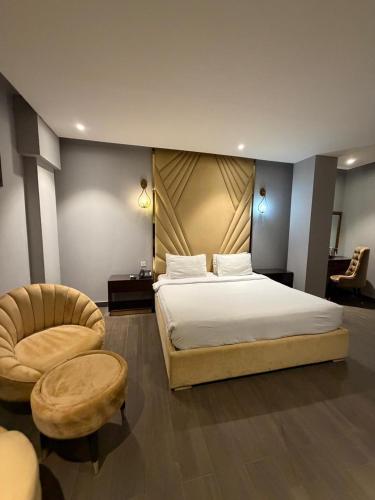 a bedroom with a large bed and a chair at Brick House Hotel Lahore in Lahore