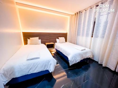 a hotel room with two beds and a window at El rincón de Valentina in Pelileo