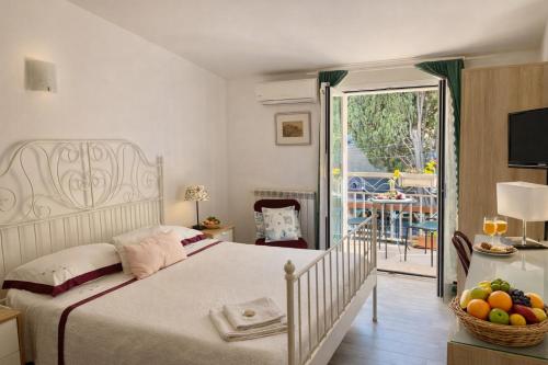 a bedroom with a bed and a balcony with a table at BlueSkyLite in Taormina
