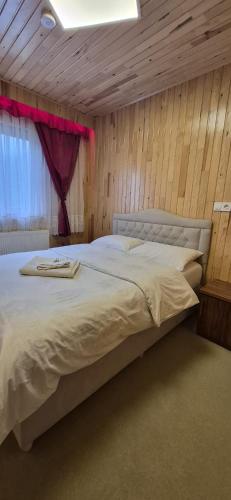 a bedroom with a large white bed with a window at AYDIN HOME Uzungöl in Uzungöl