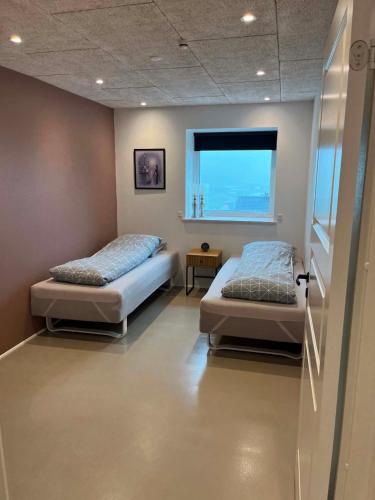 zwei Betten in einem Zimmer mit Fenster in der Unterkunft Sea view in Sørvágur