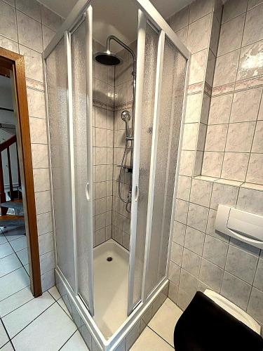 prysznic ze szklanymi drzwiami w łazience w obiekcie Casa Piccola w mieście Strullendorf