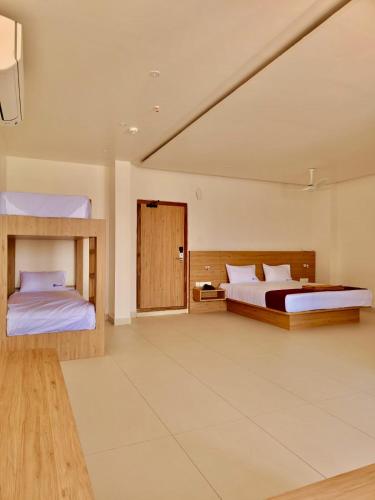 a large bedroom with two beds and a window at Trivera in Pidugurālla