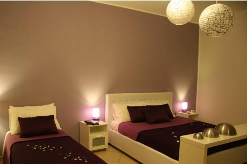 a bedroom with two beds and two lamps on tables at Modica Suite in Modica