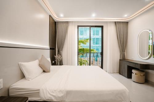 a bedroom with a large white bed and a window at Vui Hotel in Sầm Sơn
