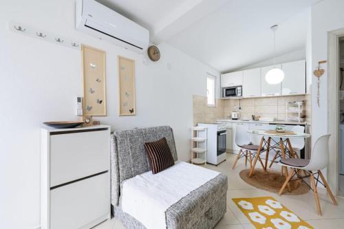 a kitchen with white cabinets and a table and chairs at Apartments Gabi&Zdenka Tivat in Tivat